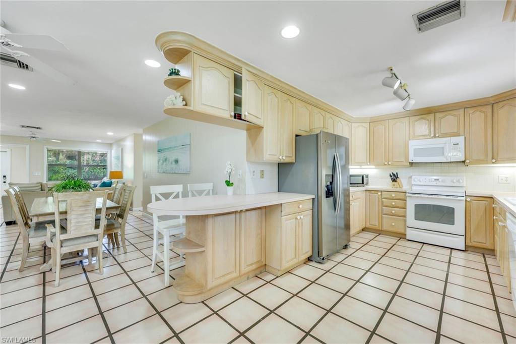 131 Cajeput Drive Naples, FL 34108 - Photo 9 of 30 a kitchen with cabinets and chairs
