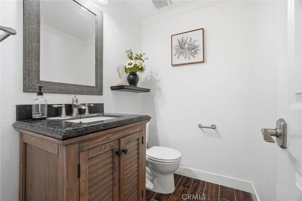 a bathroom with a granite countertop toilet sink and mirror