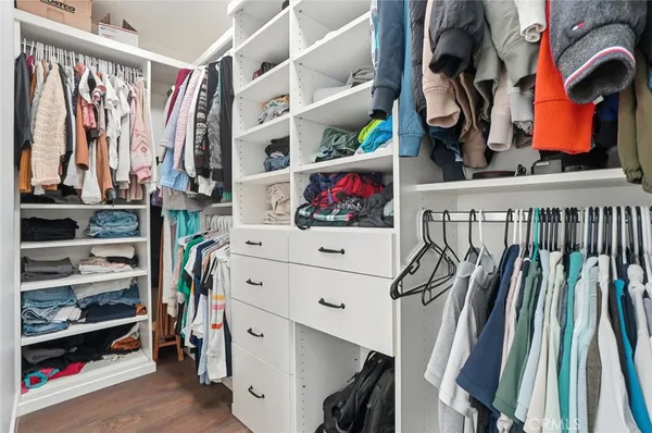 a view of walk in closet with clothes and shoes