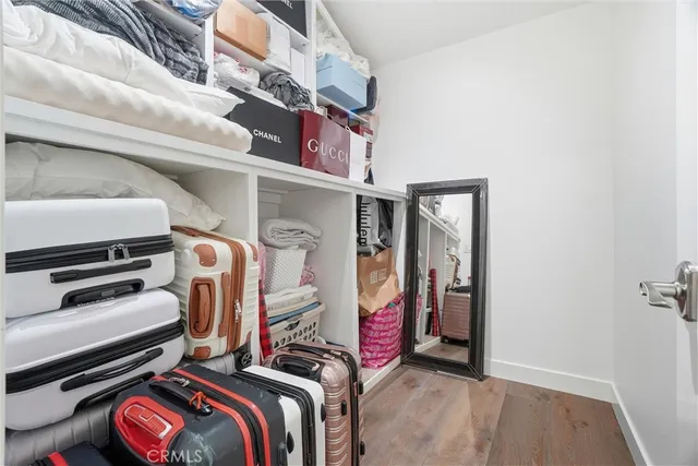 a view of walk in closet with clothes and shoes