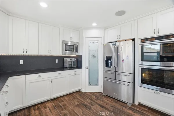 a kitchen with stainless steel appliances a refrigerator sink and microwave