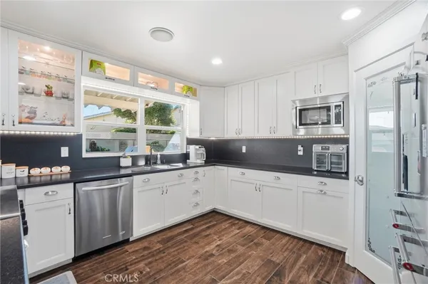 a kitchen with granite countertop white cabinets and white appliances