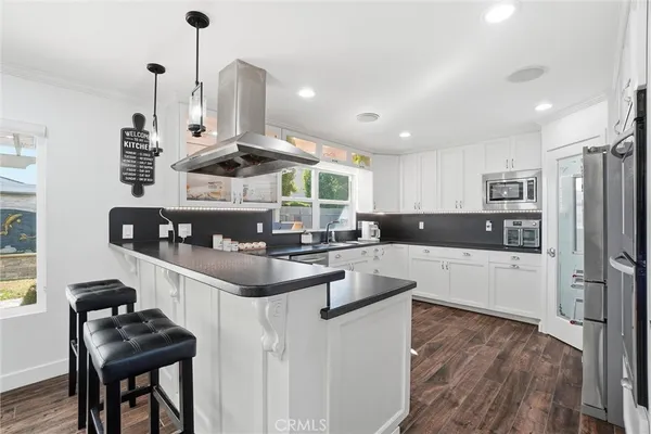 a kitchen with stainless steel appliances kitchen island a sink stove and refrigerator