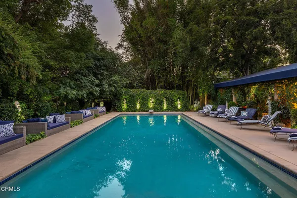 a view of a swimming pool with a patio and a yard