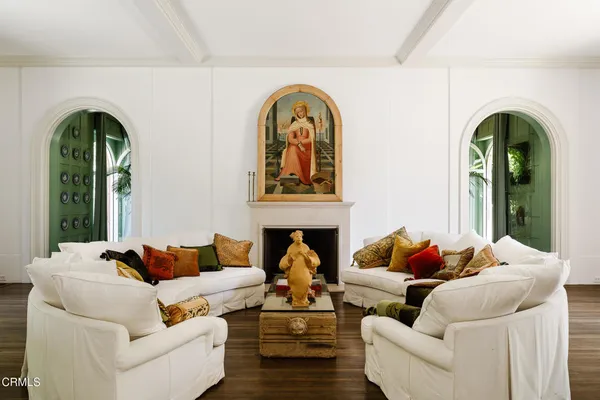 a living room with couches a fireplace with outer view