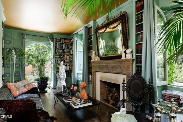a living room with furniture a fireplace and a floor to ceiling window