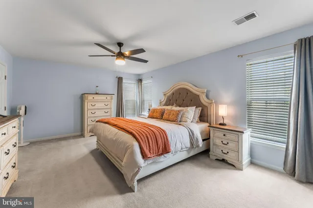 a bedroom with a bed and a ceiling fan