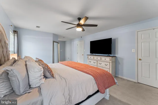 a bedroom with a bed tv and a window