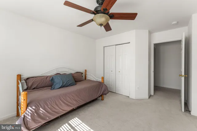 a bedroom with a bed and ceiling fan