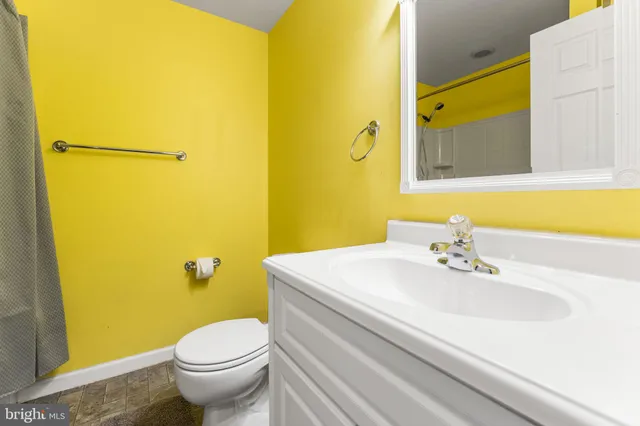 a bathroom with a sink mirror vanity and toilet