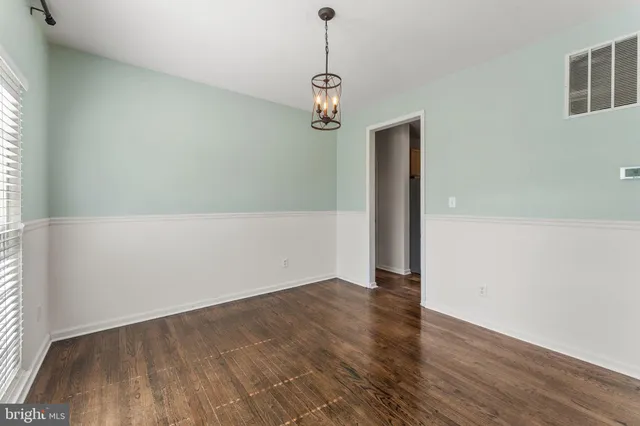 a view of a hallway with wooden floor and windows