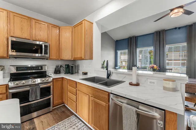 a kitchen with stainless steel appliances granite countertop a sink a stove and cabinets