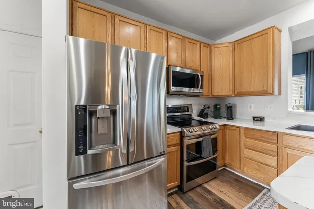 a kitchen with stainless steel appliances granite countertop a refrigerator stove and microwave