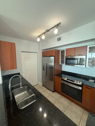 a kitchen with stainless steel appliances granite countertop a refrigerator and a stove top oven