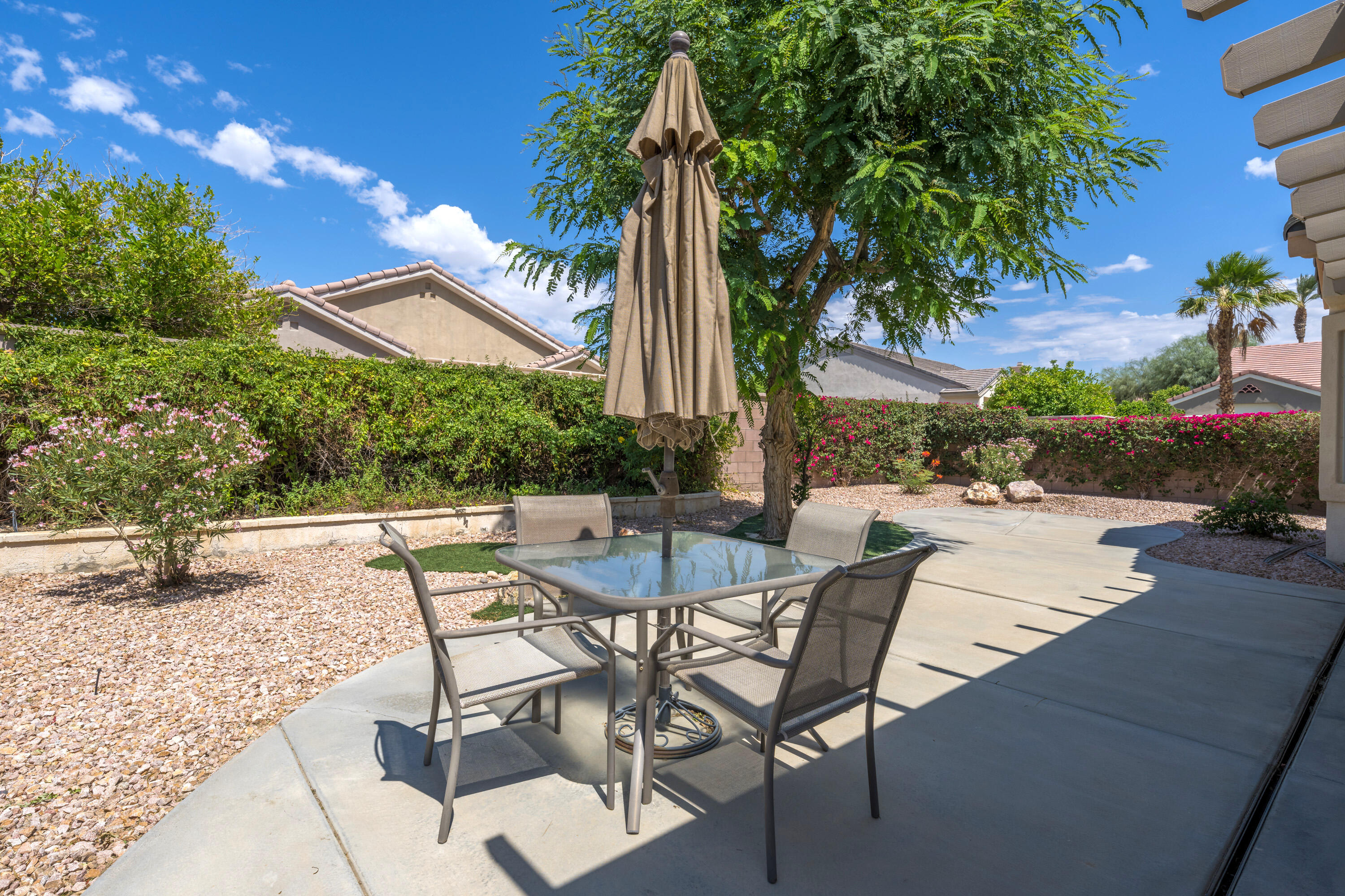 36403 Monarch Pass Palm Desert, CA 92211 - Photo 4 of 32 a view of a patio with a table and chairs under an umbrella