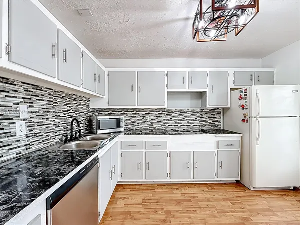 a kitchen with stainless steel appliances a refrigerator sink and cabinets
