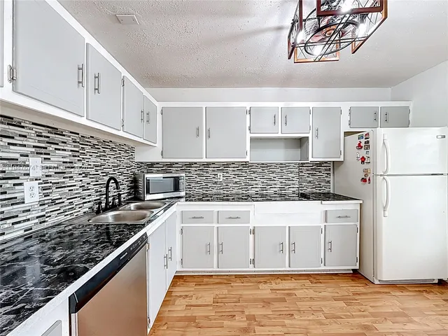 a kitchen with stainless steel appliances a refrigerator sink and cabinets