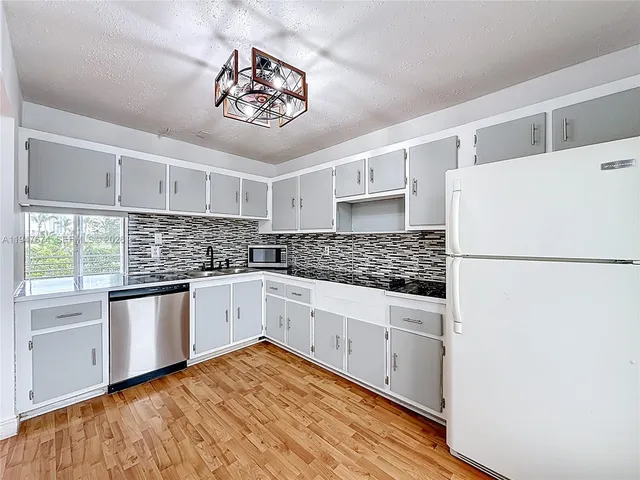 a kitchen with stainless steel appliances a white stove top oven and cabinets