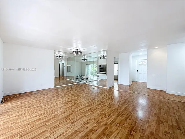 a view of a big room with wooden floor and windows