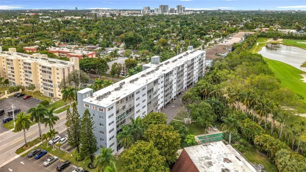 an aerial view of residential houses with outdoor space and trees