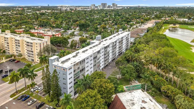 an aerial view of residential houses with outdoor space and trees