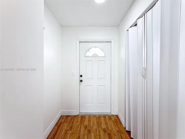 a view of a hallway with wooden floor and closet