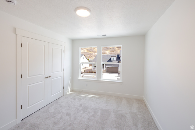 4748 Heartwood Road, Unit 434 Mapleton, UT 84664 - Photo 15 of 18 Unfurnished bedroom with carpet floors, a closet, and a textured ceiling