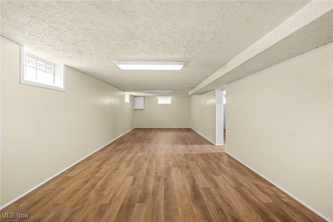 3205 George Avenue Cleveland, OH 44134 - Photo 23 of 32 Below grade area with healthy amount of natural light, wood finished floors, and a textured ceiling