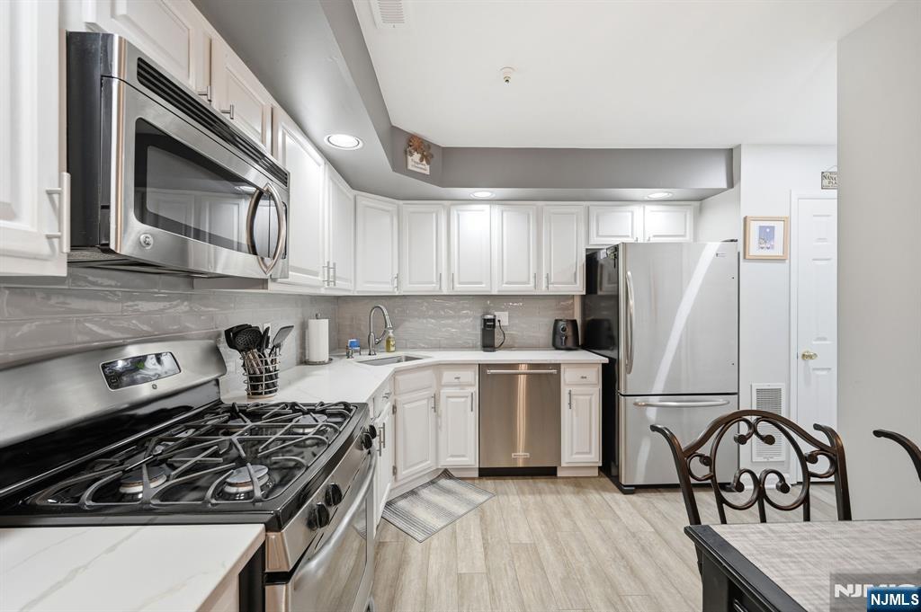 300 Coventry Court Ramsey, NJ 07446 - Photo 13 of 27 a kitchen with a stove a refrigerator and cabinets