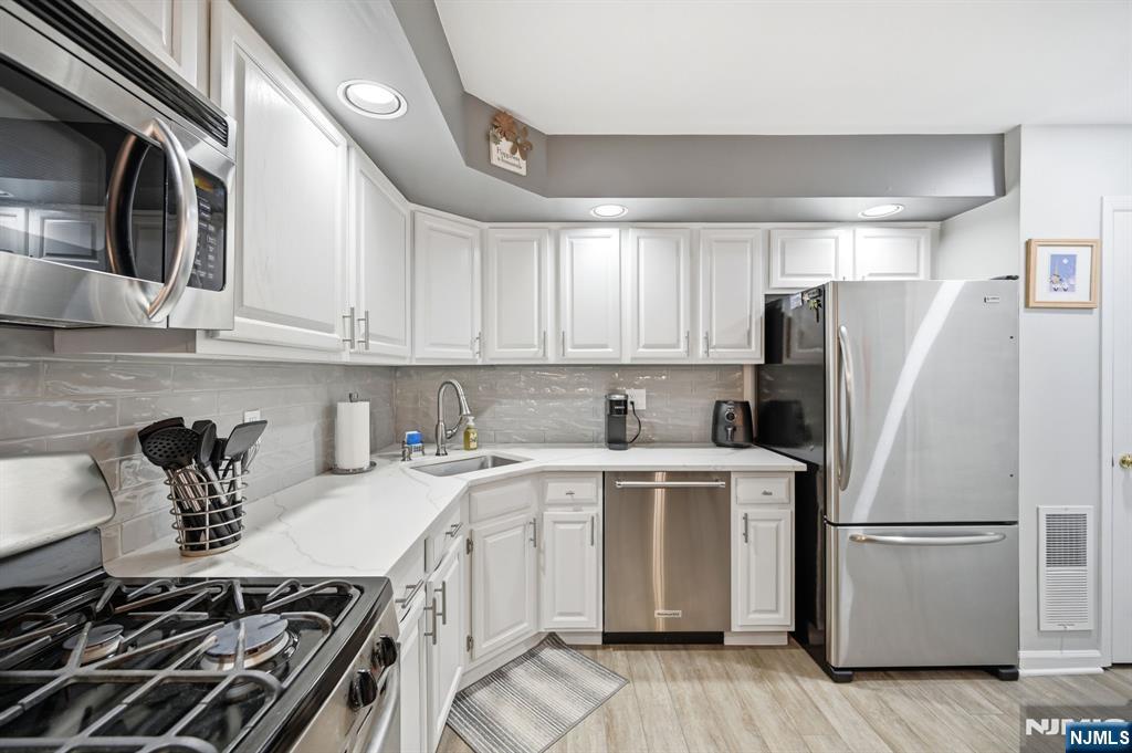 300 Coventry Court Ramsey, NJ 07446 - Photo 14 of 27 a kitchen with a white stove top oven and refrigerator