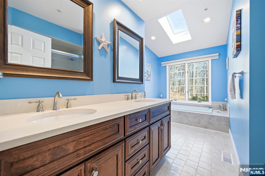 300 Coventry Court Ramsey, NJ 07446 - Photo 21 of 27 a spacious bathroom with a granite countertop sink and a large mirror