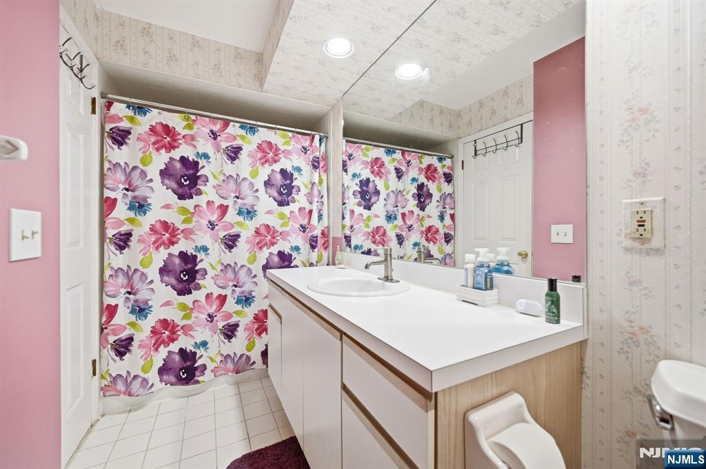 300 Coventry Court Ramsey, NJ 07446 - Photo 25 of 27 a bathroom with a sink toilet vanity and curtain