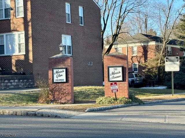 a view of a brick house with a yard and plants