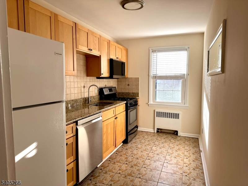 390 Morris Avenue, Unit 35 Summit, NJ 07901 - Photo 2 of 16 a kitchen with stainless steel appliances granite countertop a refrigerator a stove a sink a microwave and cabinets