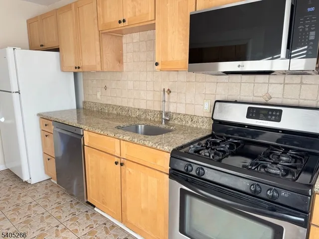 a kitchen with stainless steel appliances granite countertop a stove a microwave and a sink