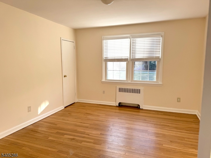 390 Morris Avenue, Unit 35 Summit, NJ 07901 - Photo 5 of 16 an empty room with wooden floor and windows