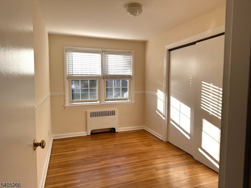 390 Morris Avenue, Unit 35 Summit, NJ 07901 - Photo 6 of 16 an empty room with wooden floor and windows