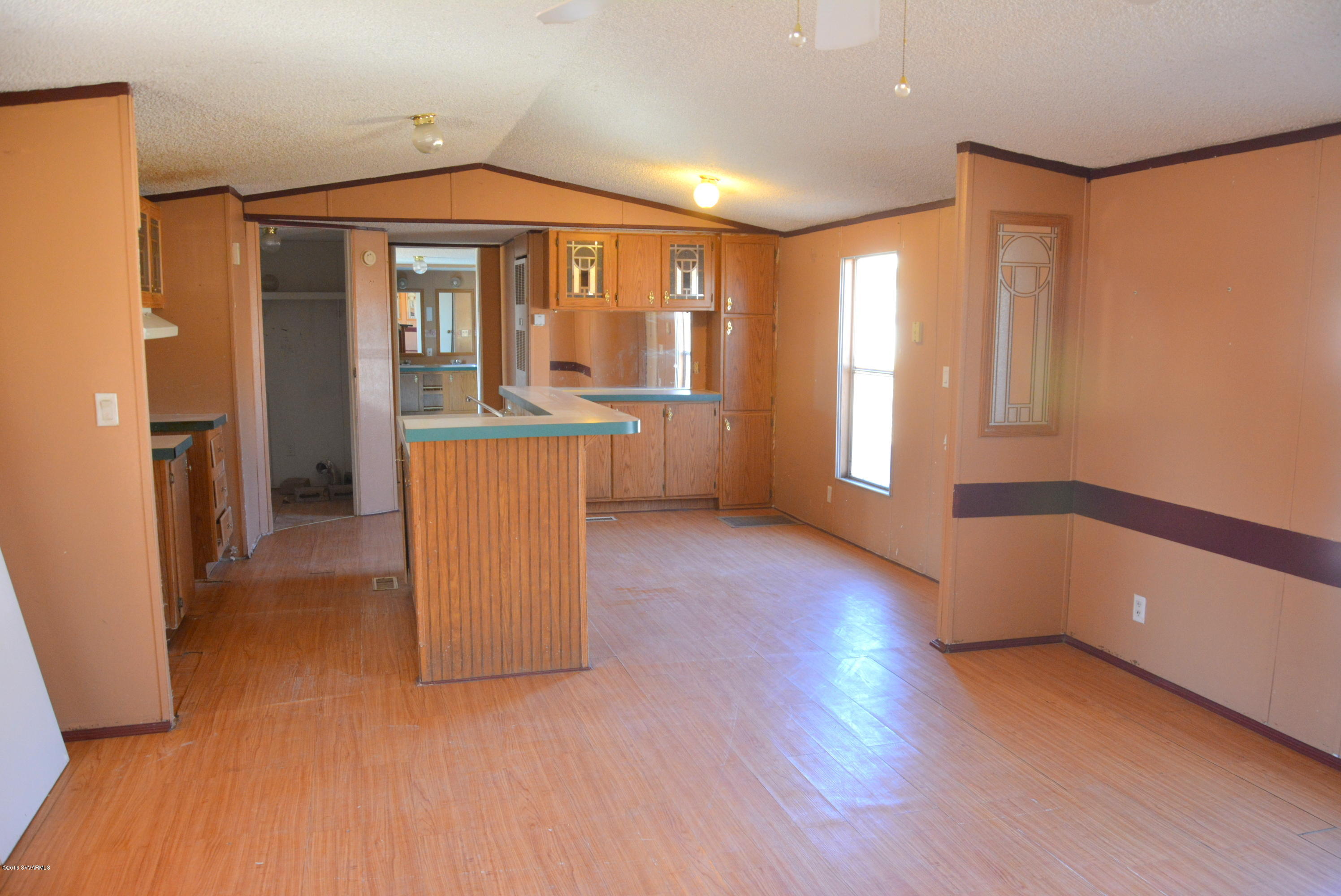 4050 Bridle Path Road Cottonwood, AZ 86326 - Photo 11 of 17 a large kitchen with a wooden floor and a refrigerator
