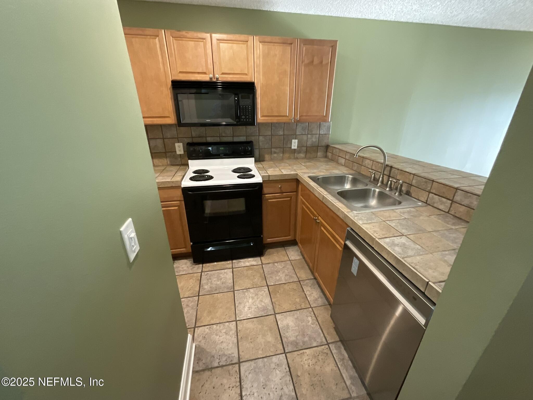 650 West Pope Road, Unit 252 St. Augustine, FL 32080 - Photo 13 of 33 a kitchen with a sink a stove a microwave and cabinets