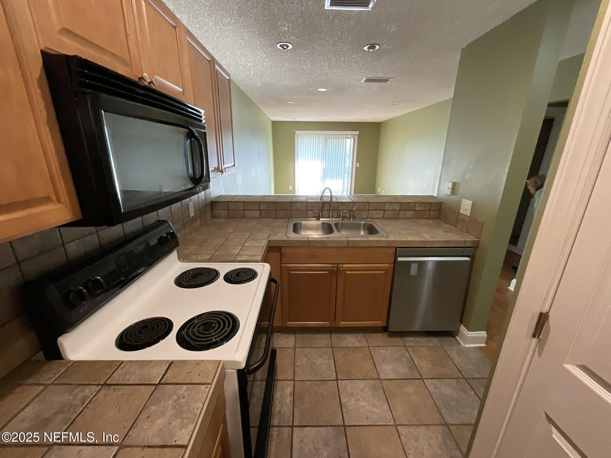 650 West Pope Road, Unit 252 St. Augustine, FL 32080 - Photo 16 of 33 a kitchen with a stove and a microwave