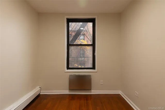 a view of a small space with wooden floor and a window