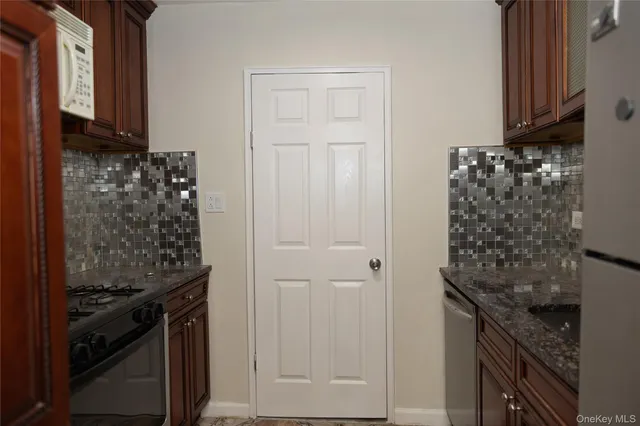 a kitchen with granite countertop a stove oven and a refrigerator