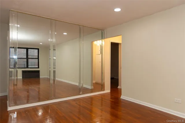 an empty room with wooden floor and entryway