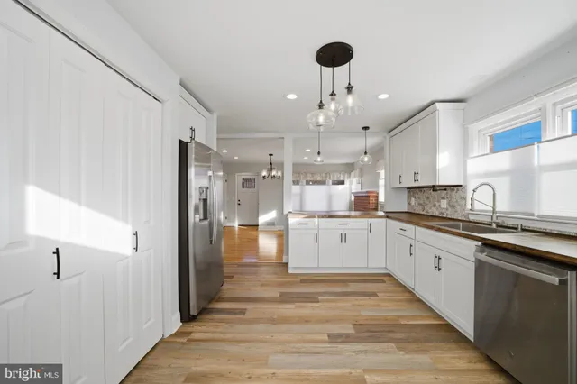 a large kitchen with granite countertop a large counter top appliances and cabinets