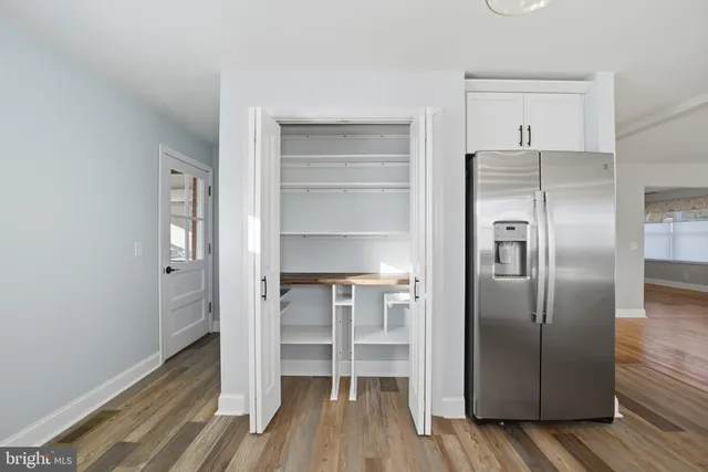 a kitchen with a refrigerator and wooden floor