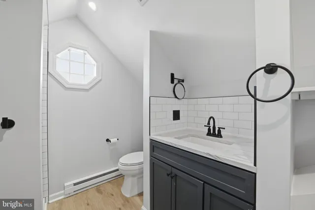 a bathroom with a granite countertop sink a toilet and a mirror