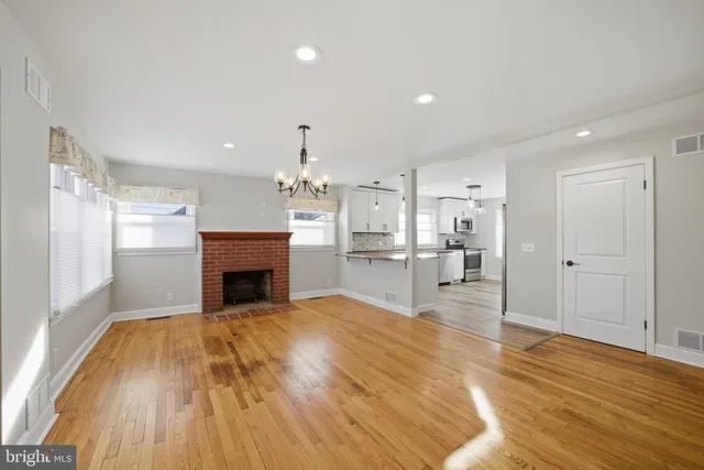 a view of empty room with wooden floor and fireplace