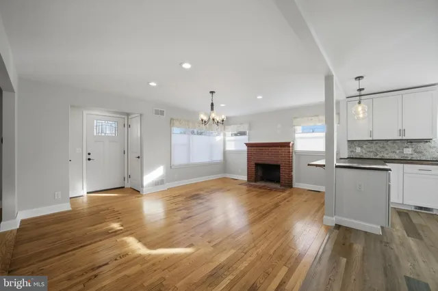 a view of a livingroom with a fireplace wooden floor and window