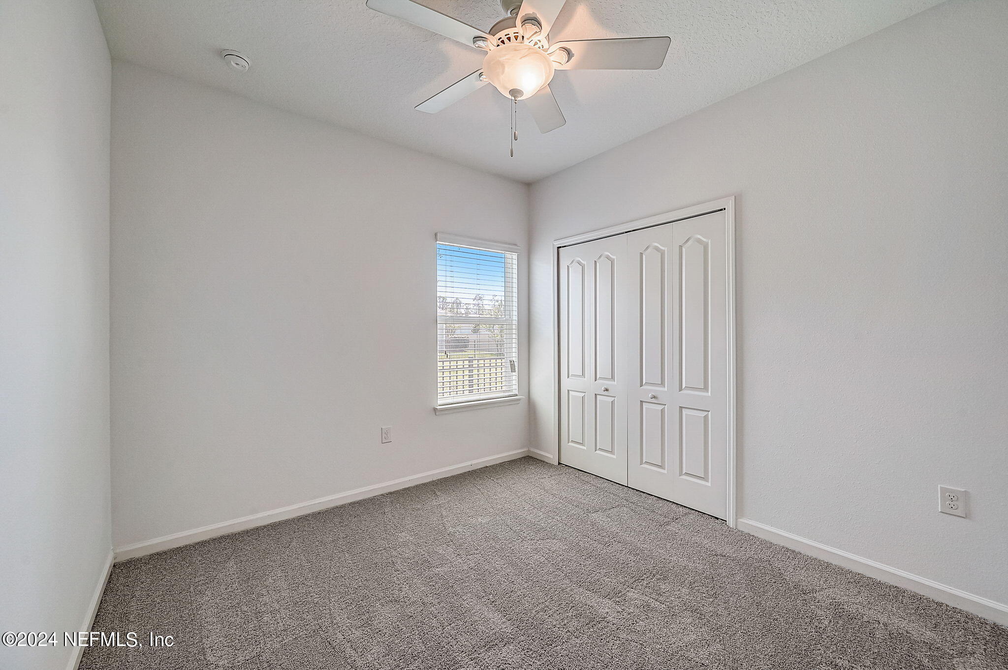 48 Martello Drive St. Augustine, FL 32092 - Photo 24 of 50 an empty room with a chandelier fan and windows