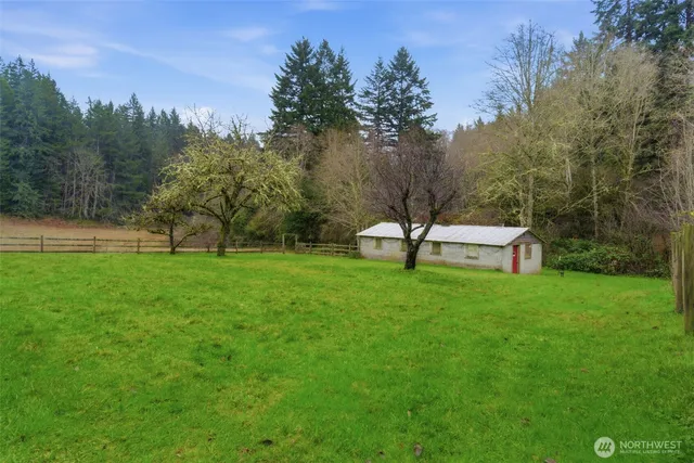a view of a park with bench sitting in the forest